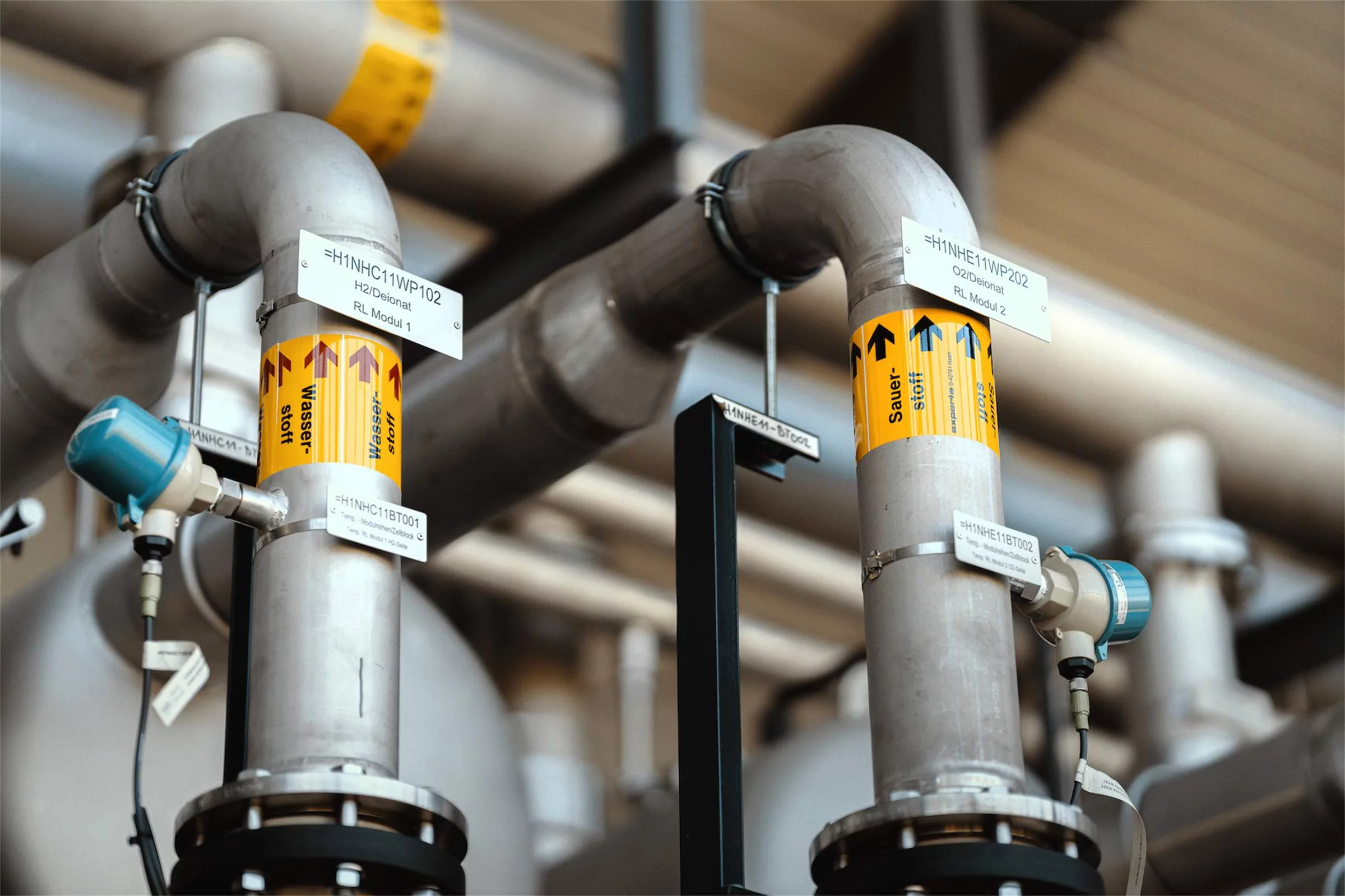 Zwei Rohrleitungen, beschriftet einmal mit "Wasserstoff", einmal mit "Sauerstoff"